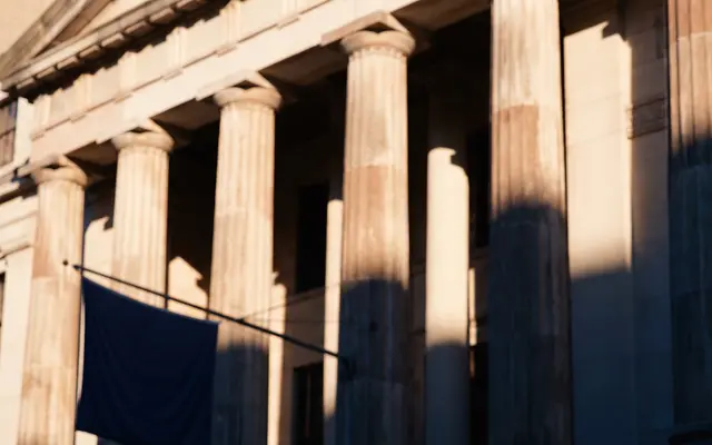 Stone columns of a classical civic building in low afternoon light